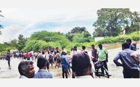 தருமபுரி மாவட்டம் இண்டூரை அடுத்த நத்த அள்ளியில் அரசு உயர்நிலைப் பள்ளிக்கு செல்லும் சாலையில் ஏற்பட்டுள்ள வெள்ளத்தை மாணவ, மாணவியர் கடந்து செல்ல உதவும் பெற்றோர், ஆசிரியர்கள் உள்ளிட்டோர்.