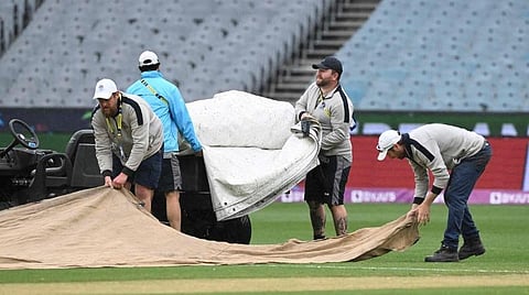 ஆடுகளத்தை கவர் செய்யும் மைதான ஊழியர்கள்