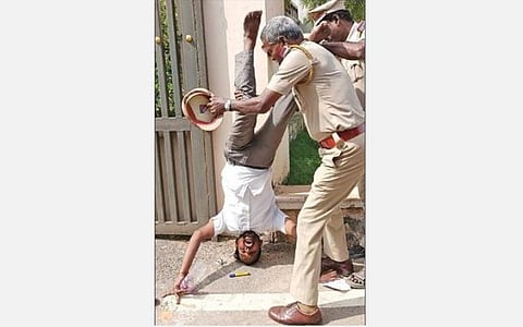 கடலூர் ஆட்சியர் அலுவலக வாயிலில் தலைகீழாக நின்று விட்டு, பின் மனுவை அளித்த விவசாயி மணி.