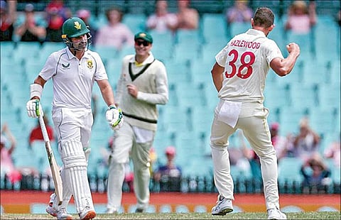 சிட்னி டெஸ்ட் கிரிக்கெட் போட்டியில் ஜோஷ் ஹேசில்வுட் பந்தில் ஆட்டமிழந்து வெளியேறிய தென் ஆப்பிரிக்க அணியின் கேப்டன் டீன் எல்கர். படம்: ஏஎப்பி