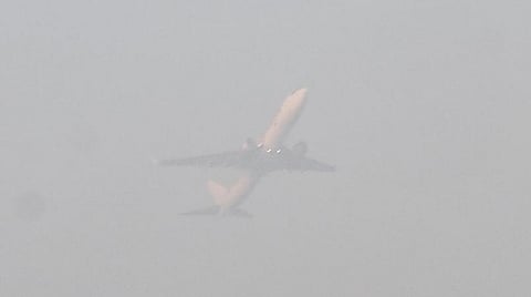 புகை மூட்டத்திற்கு நடுவே செல்லும் விமானம்