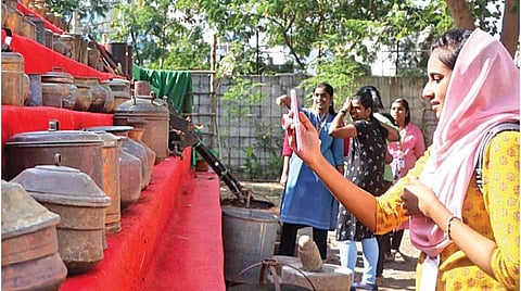 அங்கு காட்சிக்கு வைக்கப்பட்டுள்ள பழங்கால பாத்திரங்களை ஆர்வத்துடன் பார்க்கும் மாணவிகள்.| படங்கள்: ம.பிரபு |