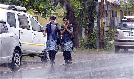 மயிலாடுதுறை நகரில் நேற்று பெய்த மழையில் நனைந்தபடி சென்ற மாணவிகள்.