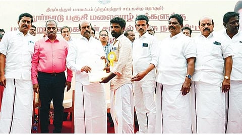 திருப்பத்தூர் மாவட்டம் புதூர் நாடு மலை கிராமத்தில் நடந்த விழாவில் பயனாளி ஒருவருக்கு நலத்திட்ட உதவியை வழங்கிய பொதுப்பணி துறை அமைச்சர் எ.வ.வேலு. அருகில், ஆட்சியர் பாஸ்கர பாண்டியன் உள்ளிட்டோர்.