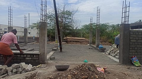 திருப்பூர் மாநகராட்சியில் புதிதாக கட்டப்படும் கழிப்பிடத்தின் மத்தியில் மின்கம்பம்