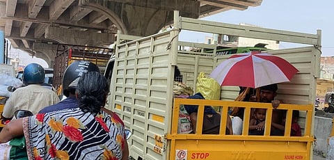 கோவை  ஆத்துப்பாலம் சாலையில் சுட்டெரிக்கும் வெயிலில் வாகனத்தில் குடை பிடித்தபடி செல்லும் மக்கள்  .படம் .ஜெ மனோகரன்