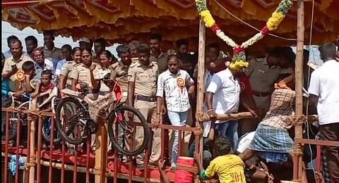 அய்யம்பட்டி ஜல்லிக்கட்டில் பாதுகாப்பு பணியை மேற்கொள்ளாமல் பார்வையாளர்களாக மேடையில் அமர்ந்து கொண்ட போலீஸார்.