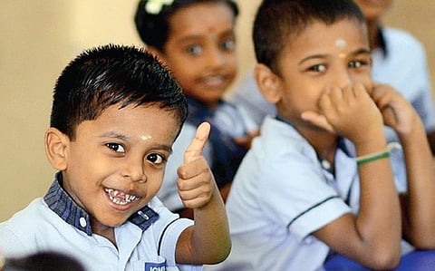 பள்ளிக்கு வந்த உற்சாகத்தில் விரலை உயர்த்தி மகிழ்ச்சியை வெளிப்படுத்திய சிறுவன். படங்கள்: எஸ்.சத்தியசீலன்