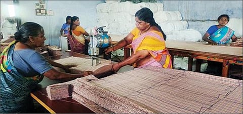 விருதுநகரில் பள்ளி மாணவர்களுக்கான இலவச சீருடை தைப்பதற்காக துணிகளை இயந்திரம் மூலம் அளவெடுத்து வெட்டும் தொழிலாளர்கள்.