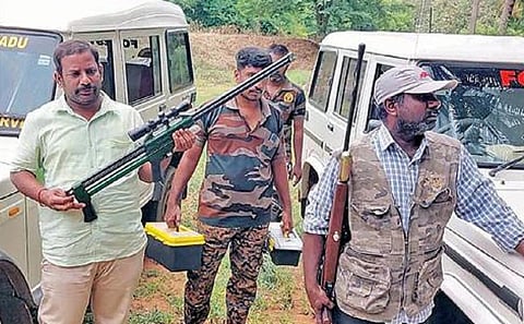 ‘பாகுபலி’ யானைக்கு மயக்க ஊசி செலுத்த ஏதுவாக துப்பாக்கி களுடன் காத்திருக்கும் வனத்துறையினர் மற்றும் கால்நடை மருத்துவக் குழுவினர்.