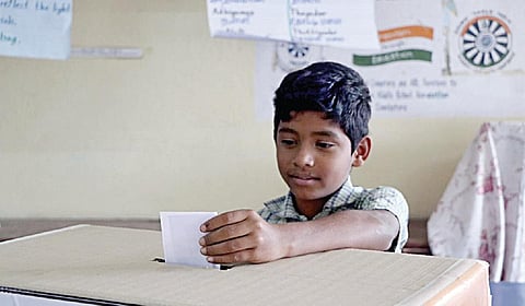 வாக்கு செலுத்தும் மாணவன்.