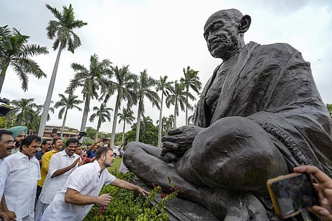 எம்.பி. பதவி மீண்டும் வழங்கப்பட்டதை அடுத்து, நாடாளுமன்ற வளாகத்துக்கு நேற்று வந்த ராகுல் காந்தி, அங்குள்ள மகாத்மா காந்தி சிலையை தொட்டு வணங்கினார். படம்: பிடிஐ