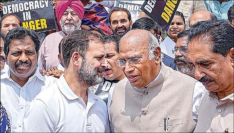 மத்திய அரசின் நடவடிக்கையை  கண்டித்து டெல்லியில் உள்ள நாடாளுமன்ற வளாகத்தில் எதிர்க்கட்சி எம்.பி.க்கள் நேற்று போராட்டம் நடத்தினர். அப்போது காங்கிரஸ் தலைவர் மல்லிகார்ஜூன கார்கேவிடம் பேசுகிறார், காங்கிரஸ் எம்.பி. ராகுல் காந்தி. படம்: பிடிஐ