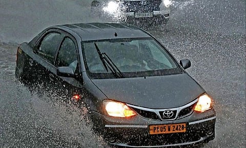 சென்னையில் நேற்று மதியம் திடீரென இருள் சூழ்ந்து மழை கொட்டித் தீர்த்தது. இதன் காரணமாக மெரினா கடற்கரை காமராஜர் சாலையில் தேங்கிய மழை நீரில் சீறியபடி சென்ற கார். படம்: பிரபு