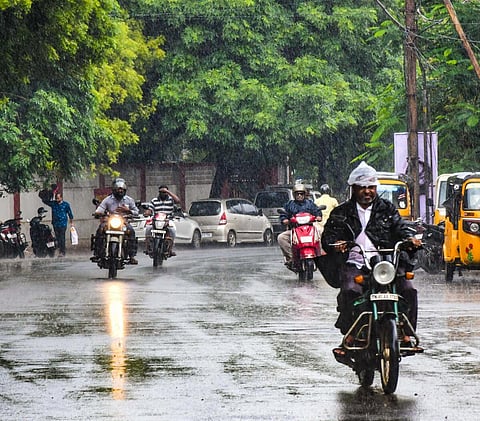 திருச்சி கன்டோன்மென்ட் பகுதியில் நேற்று காலை பெய்த திடீர் மழையில் நனைந்தபடி செல்லும் வாகன ஓட்டிகள்.