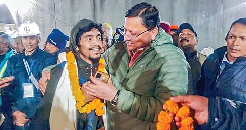 உத்தராகண்ட் மாநிலம் சில்க்யாரா சுரங்கப் பாதையில் 17 நாட்களாக சிக்கித் தவித்த 41 தொழிலாளர்களும் நேற்று பத்திரமாக மீட்கப்பட்டனர். அவர்களுக்கு மாலை அணிவித்து வரவேற்ற முதல்வர் புஷ்கர் சிங் தாமி.படம்: பிடிஐ