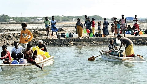 டிசம்பர் மாத மழை, வெள்ளத்தால் தூத்துக்குடி அருகே சாலை துண்டிக்கப்பட்டதால் போயா படகு மூலம் குடிநீர் குடங்களுடன் பயணிக்கும் கோவளம் மீனவர் காலனி மக்கள். | படங்கள்: என்.ராஜேஷ் |