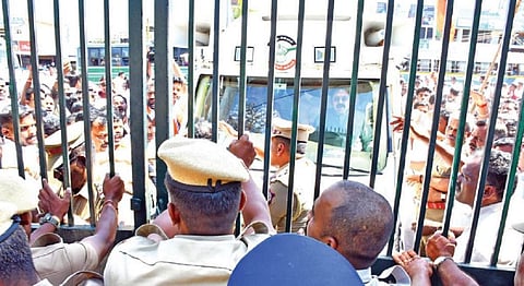 தேனியில் வேட்பு மனு தாக்கல் செய்ய வந்த டிடிவி தினகரன் வேனில் அதிக ஆட்களுன் வந்ததால் இரும்புக்கேட்டை பூட்டி அனுமதிக்க மறுத்த போலீஸார். படம்:நா.தங்கரத்தினம்.