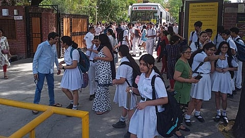 டெல்லியில் உள்ள பள்ளிகளுக்கு நேற்று  வெடிகுண்டு மிரட்டல் விடுக்கப்பட்டதால், நொய்டாவில் உள்ள டெல்லி பப்ளிக் பள்ளிக்கு வெளியே மாணவ, மாணவியர் மற்றும் பெற்றோர் பதற்றத்துடன் காணப்பட்டனர். படம்: பிடிஐ