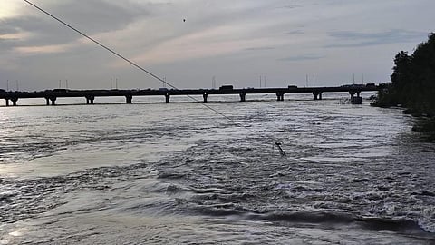 திருச்சி திருவானைக்கோவில் நம்பர் ஒன் டோல்கேட் இடையே கொள்ளிடம் புதிய பாலம் அருகே இன்று அதிகாலை ஆற்றில் சாய்ந்து விழுந்த உயர் மின்னழுத்த கோபுரம். | படம் ர.செல்வ முத்துகுமார்