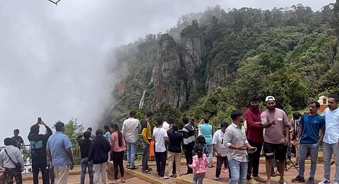 கொடைக்கானலில் உள்ள சுற்றுலா தலமான தூண் பாறையை மேகக்கூட்டங்கள் தழுவிச் செல்லும் இயற்கை எழிலை கண்டு ரசிக்கும் சுற்றுலா பயணிகள்.