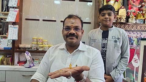 சிறிய அளவு தங்கத்தில் செய்யப்பட்ட நடராஜர் கோவில் தேருடன் பொற்கொல்லர் முத்துக்குமரன்.