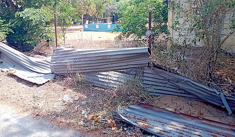 காஞ்சிபுரம் ஆயுதப்படை மைதானத்தில் உடைந்த நிலையில் காணப்படும் தகரத்தால் ஆன தடுப்புச் சுவர்.