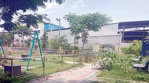 பூங்காவுக்குள் புதர் மண்டிய நிலையில் உள்ள இருக்கைகள்.