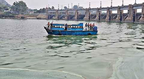 மேட்டூர் அணையில் பச்சை படலமாக  மாறிய தண்ணீர், துர்நாற்றத்தை கட்டுப்படுத்த திறனூட்டப்பட்ட நுண்ணுயிர் திரவ கலவை தெளிக்கும் பணியில் ஈடுபட்ட ஊழியர்கள்.