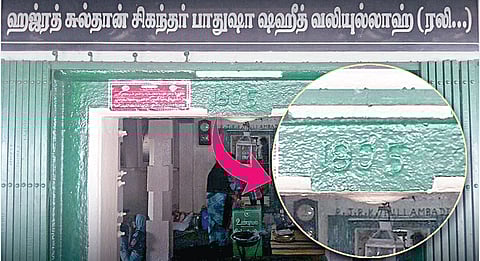 திருப்பரங்குன்றம் மலை மீதுள்ள சிக்கந்தர் பாதுஷா தர்கா முகப்பில் உள்ள கல்வெட்டில் 1805 எனக் குறிப்பிட்டுள்ளதாக இணையத்தில் வைரலாகி வரும் படம்.