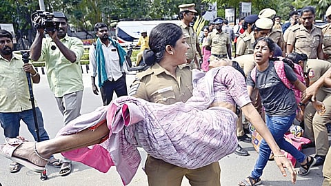 போராட்டத்தின்போது மயங்கி விழுந்த நாமக்கல் ஆசிரியை மகேஸ்வரியை தூக்கிச் சென்ற காவலர். | படங்​கள்: ம.பிரபு |