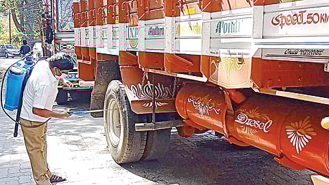 நீல​கிரி மாவட்​டம் நாடு​காணி சோதனைச் சாவடி​யில் கேரளா​விலிருந்து வரும் வாக​னங்​களுக்கு கிருமி நாசினி தெளித்த கால்​நடை மருத்​து​வக் குழுவினர்​.