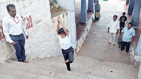 திருச்​செங்​கோடு அர்த்த​நாரீஸ்வரர் மலைக்​கோ​யில்&nbsp; படிக்​கட்​டில் யோகாசனம் செய்​த​படி சென்​ற சிறுமி ஹ​னா.