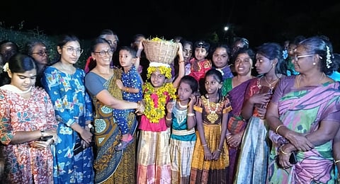 வேடசந்தூர் அருகே கோட்டூர் கிராமத்தில் நடைபெற்ற நிலாப்பெண் வழிபாட்டில், ஆவாரம்பூ கூடையுடன் அழைத்துவரப்பட்ட சிறுமி.