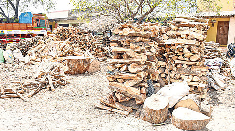 மதுரை மாட்டுத்தாவணி அருகே உள்ள கடையில் விற்பனைக்காக குவித்து வைக்கப்பட்டிருக்கும் விறகுகள்.&nbsp;