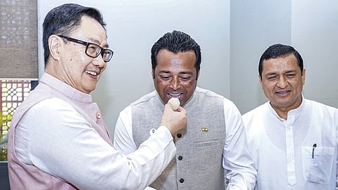 டெல்லியில் நேற்று நடைபெற்ற நிகழ்ச்சியில் பாஜகவில் இணைந்த டென்னிஸ் நட்சத்திரம் லியாண்டர் பயஸுக்கு இனிப்பு ஊட்டுகிறார் மத்திய அமைச்சர் கிரண் ரிஜிஜு. உடன் பாஜக எம்.பி. அனில் பலுனி. படம்: பிடிஐ