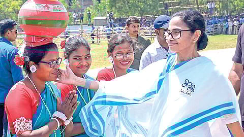 மேற்கு வங்க தேர்தல் பிரச்சாரத்துக்காக நேற்று தக் ஷின் தினாஜ்பூர் வந்த முதல்வர் மம்தா பானர்ஜிக்கு வரவேற்பு அளிக்கப்பட்டது. அப்போது நடனக் கலைஞர்களுடன் மம்தா கலந்துரையாடினார். படம்: பிடிஐ