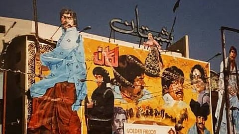 Large hand-painted 1980s Pakistani film billboard featuring action heroes and Urdu typography installed above Shalimar Cinema.