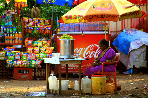 A woman street vendor selling drinks on hot streets in India