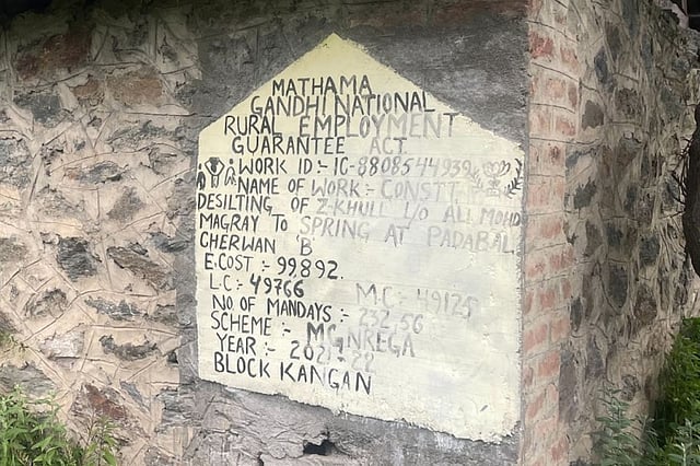 A government sign marks a spring-restoration effort in Padabal, Kangan block, Ganderbal district - part of a rural employment guarantee scheme.