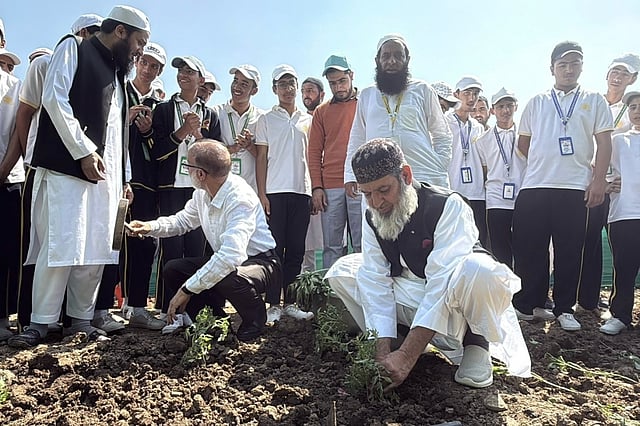 Manzoor Wangnoo (kneeling, right) joins students in a tree-planting drive. He works to restore Kashmir’s drying water springs.