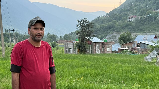 Yaqoob stands in his paddy field. He says low profits and a lack of irrigation forced him to stop farming most of his land.
