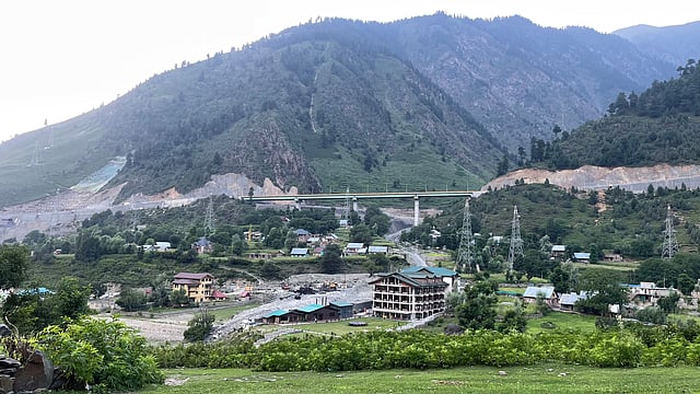 A new highway bridge cuts across the hillside, a clear sign of development that is reshaping the valleys and local life