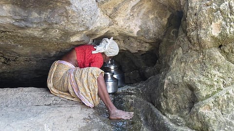 अकोले के एक स्प्रिंग से पानी के लिये जद्दोजहद करती महिला