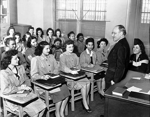 Principal Mortimer C. Ritter addresses an academic class at the Needle Trades High School, New York, in April 6, 1944. Students include Fergel Levine, Jean Cultrera, and Ellen Perino