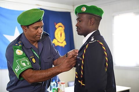 AMISOM Commissioner of Police Brigadier Anand Pillay pins a medal on the lapel of an Individual Police Officer from Kenya on a one year tour in Somalia