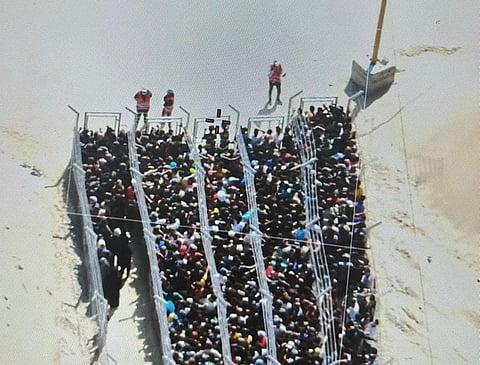 Desperate Palestinians in Gaza navigate barriers for scarce food rations, part of a so-called 'humanitarian project'.