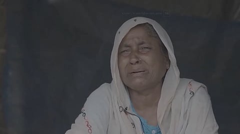 A Muslim woman in distress, her face etched with pain, questioning the relentless suffering imposed upon her community.
