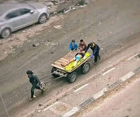 A makeshift ambulance in Gaza, where a person is transported on a wooden cart pulled by hand due to Israel's systematic destruction medical infrastructure.