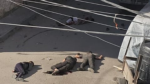 A scene in Gaza with multiple bodies of Palestinians killed by Israel on a street.